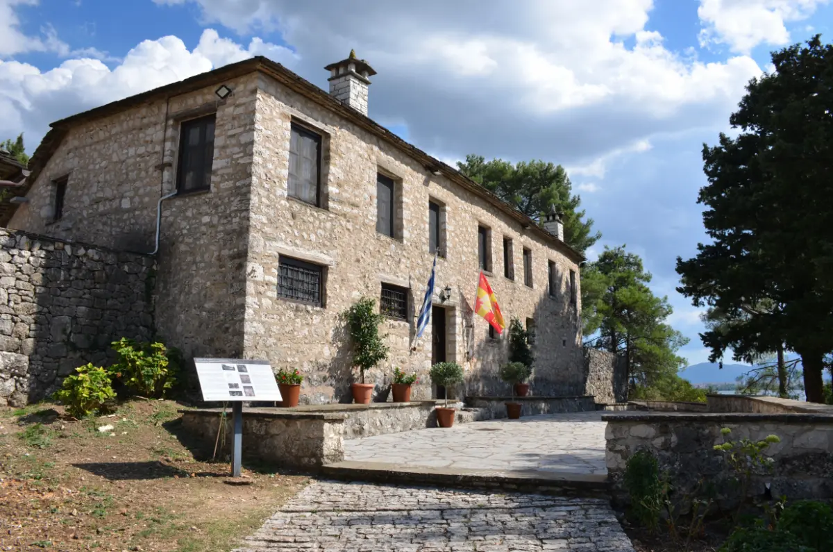 Monastery of Saint Nicholas on Ioannina Island, stone monastery with courtyard and flags overlooking Lake Pamvotida, Greece