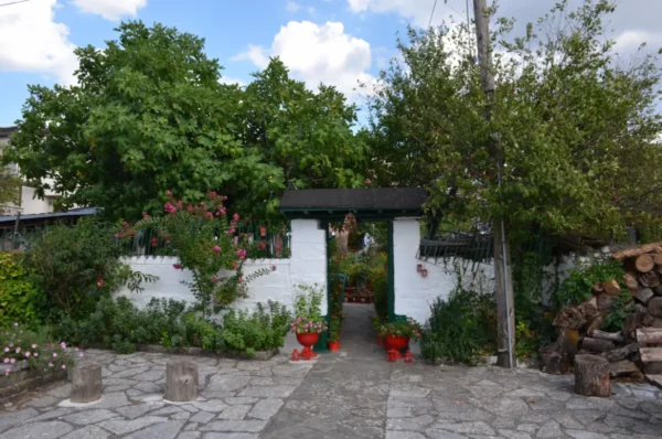 Quaint garden entrance adorned with vibrant flowers and greenery, showcasing local charm in Ioannina, Greece.