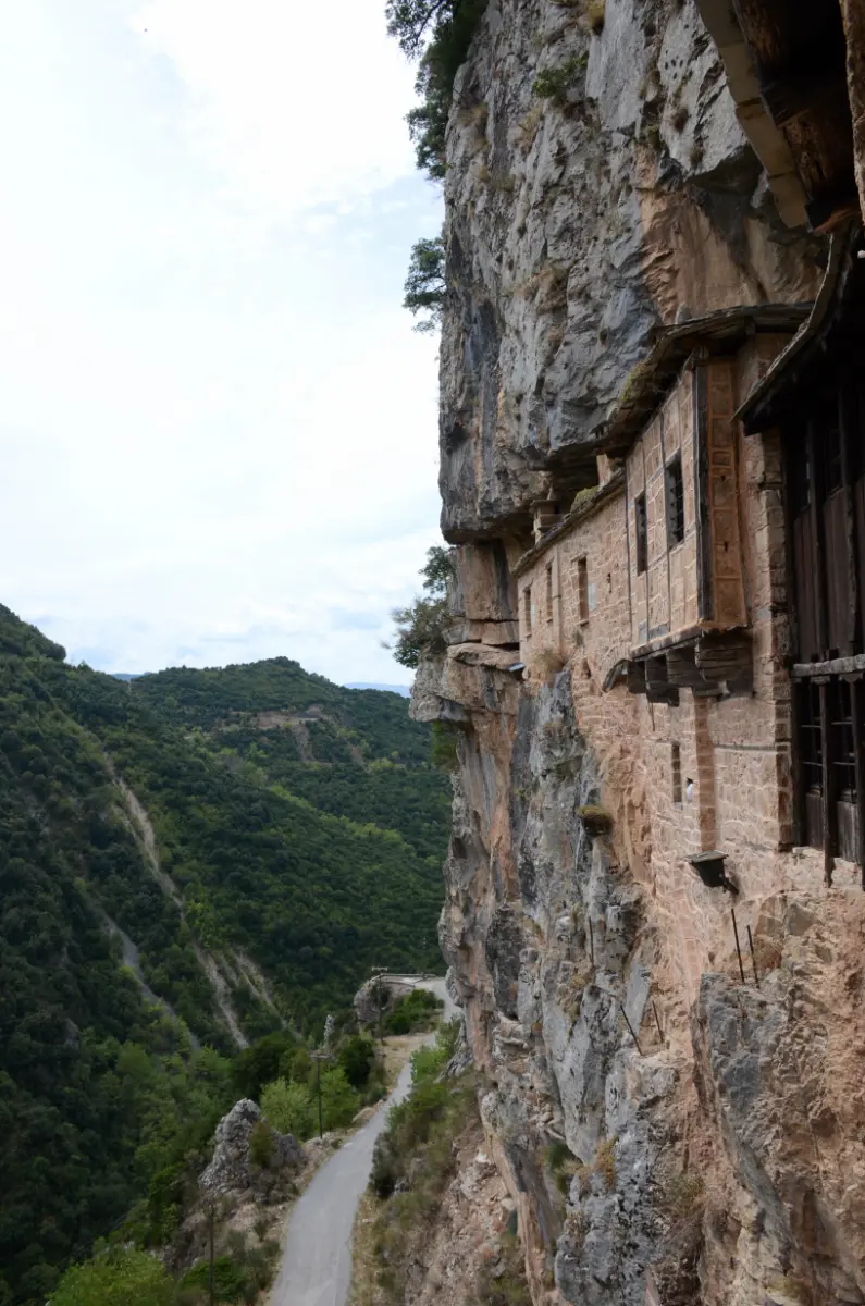 Kipina Monastery in Tzoumerka — stone monastery built into a vertical cliff above the mountain road.