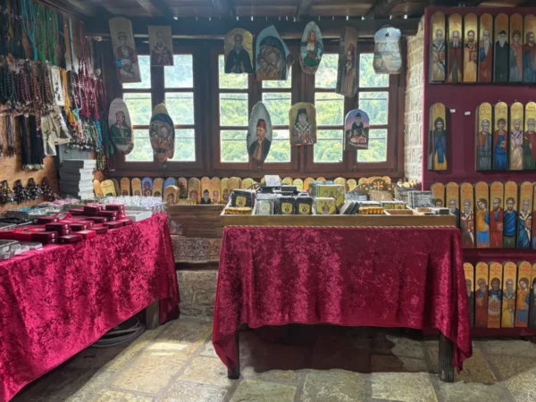 Souvenir shop inside Kipina Monastery — icons, religious items, and wooden crafts displayed on tables.
