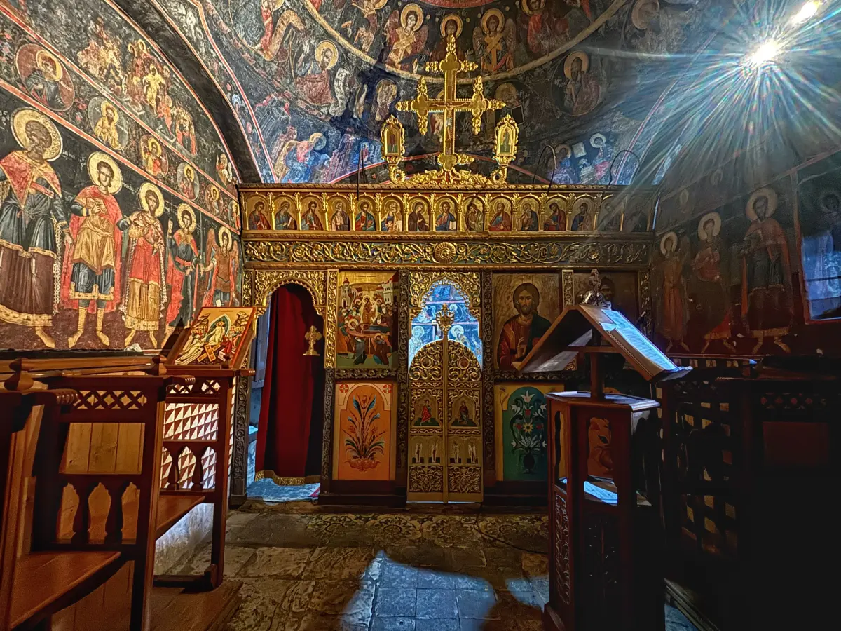 Interior of Kipina Monastery — fresco-covered chapel with a gilded iconostasis in Tzoumerka, Epirus.