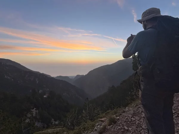 A hiker captures the colorful sunset over the rugged mountains of Mount Olympus, Pieria, Greece.