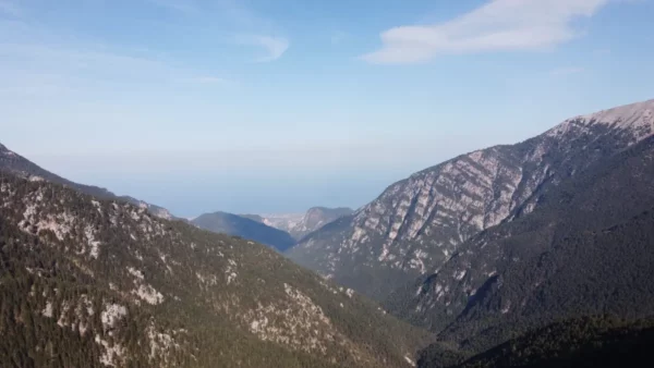 Stunning view of Mount Olympus in Pieria, Greece, showcasing majestic peaks and lush green valleys under a clear blue sky.