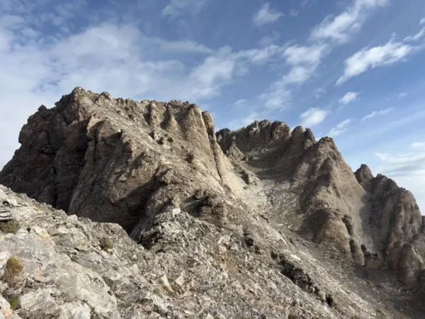 Jagged rocky peaks of Mount Olympus under a blue sky in Pieria, Greece, showcasing dramatic textures and natural beauty.