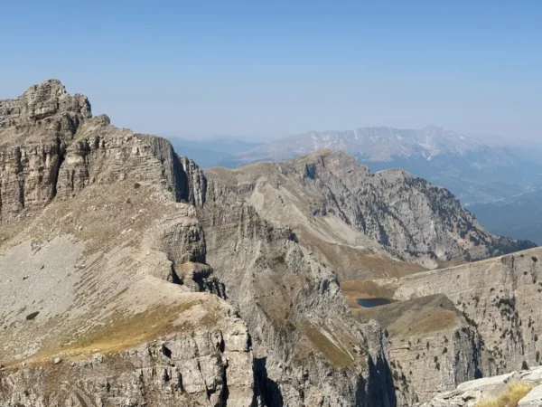 Dragon Lake (Drakolimni) of Mount Tymfi seen from above, a small alpine lake nestled in a rocky karst basin below Gamila Peak.