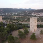 Twin medieval towers of Mytikas overlooking the Lelantine Plain, with the Castle of Fylla visible in the background, central Evia, Greece