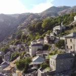 Syrrako village in Tzoumerka, Epirus — stone-built houses on the mountainside with dramatic alpine scenery.