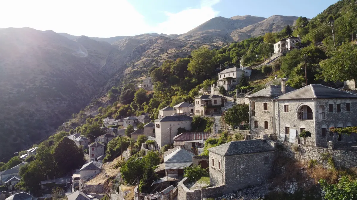 Syrrako village in Tzoumerka, Epirus — stone-built houses on the mountainside with dramatic alpine scenery.
