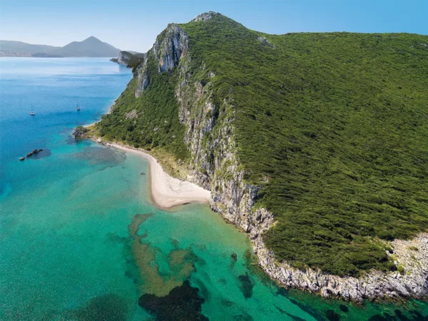 beach below vertical cliffs on Sphacteria Island, messenia, greece