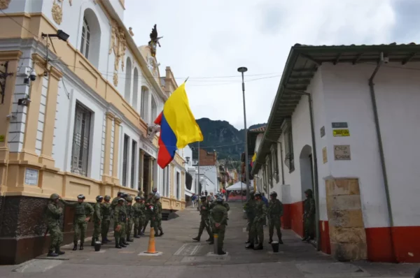 Colombian soldiers standing in formation beneath a large national flag in La Candelaria, Bogotá
