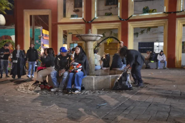 People relaxing around the central fountain at Chorro de Quevedo in La Candelaria, Bogotá, late at night