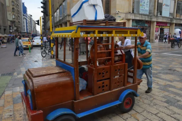 Wooden beverage cart being pushed through a busy street in Las Nieves, Bogotá