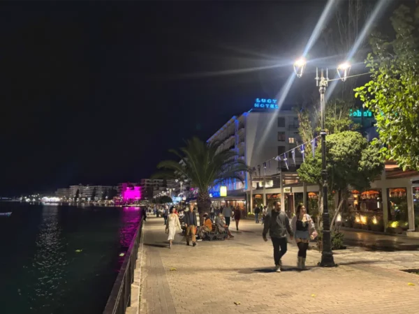 Vibrant waterfront promenade in Chalkis, Euboea, Greece, featuring palm trees, colorful lights, and evening strolls by the sea.