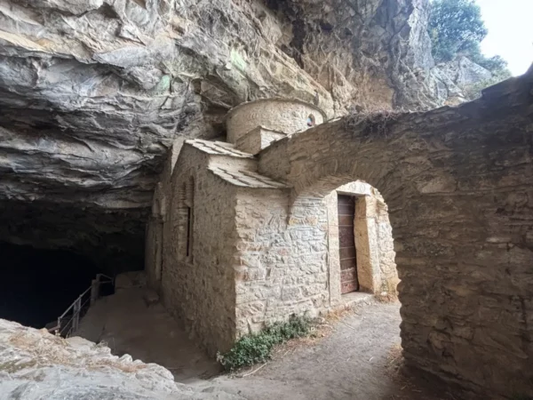 Davelis Cave features a stone chapel and rocky cliffs, nestled in Mount Pentelicus, Attica, Greece.