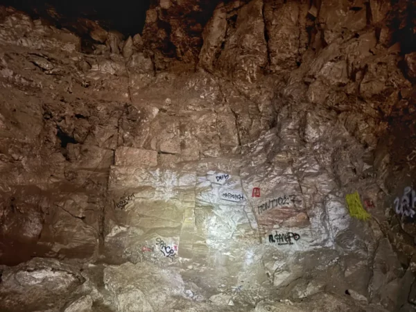 Ancient rock formations with graffiti adorn the walls of Davelis Cave in Mount Pentelicus, Attica, Greece.