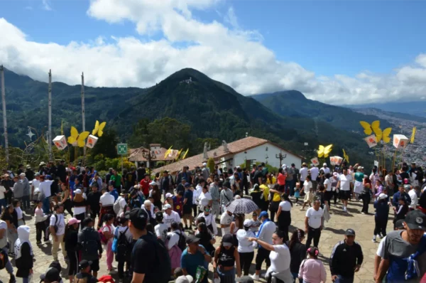 Visitors gathered outside the Basílica del Señor Caído de Monserrate with the surrounding Andean mountains in the background