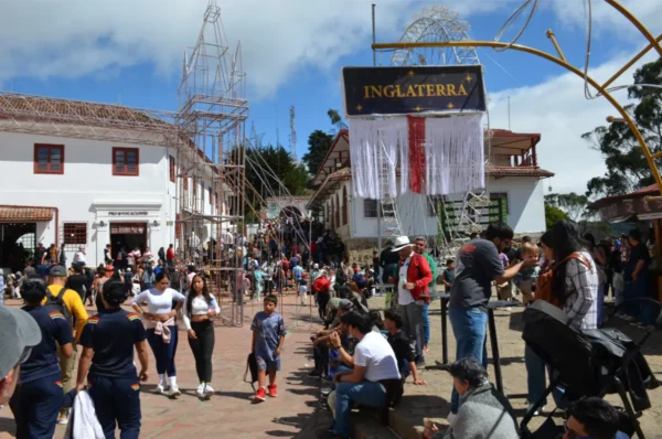 Crowds walking through the main square at the summit of Monserrate in Bogotá beneath decorative festival arches