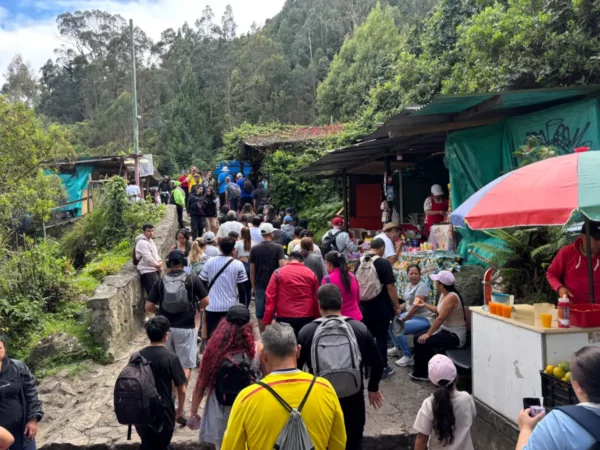 Crowds walking along the main pathway at the summit of Monserrate in Bogotá, with market stalls and food vendors on either side