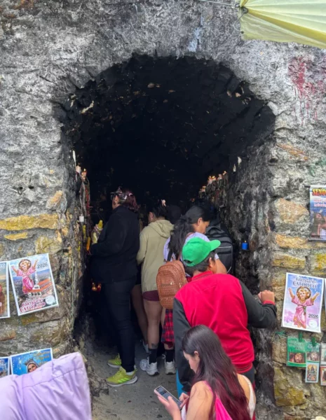 Visitors entering the candle-lit grotto along the Monserrate hiking trail in Bogotá