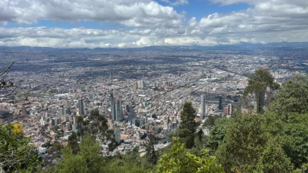 Panoramic view of Bogotá from the summit of Monserrate, with the city stretching across the Andean plateau beneath dramatic clouds