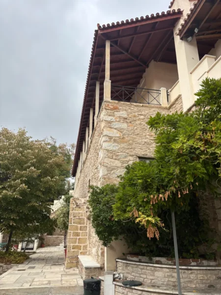 Penteli Monastery features rustic stone architecture and lush greenery, nestled in the serene landscape of Attica, Greece.