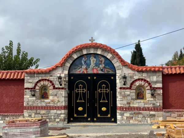 Intricate stone façade with arched doorway featuring religious paintings, located at Saint Panteleimon Monastery, Mount Pentelicus, Attica, Greece.