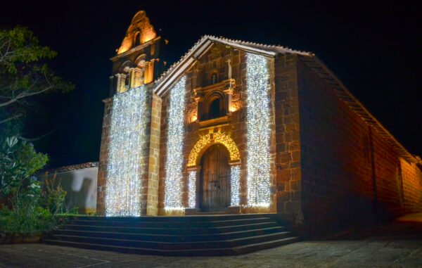 The beautifully illuminated church in Barichara, Santander, Colombia, showcases stunning architectural details against the night sky.