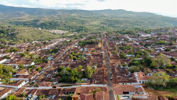 Aerial view of Barichara, Santander, showcasing its charming red-tiled roofs and lush mountainous landscape in the background.