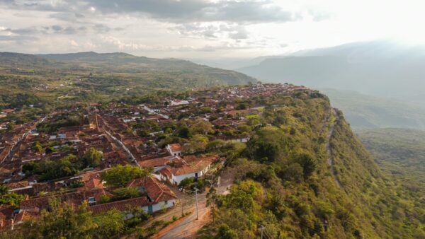 Aerial view of Barichara’s red-tiled colonial houses on a ridge above a steep green canyon