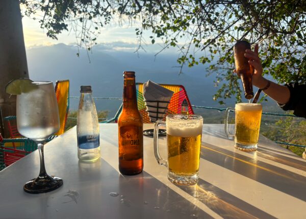 Drinks on a terrace in Independencia restaurant in Barichara at sunset, with beer and a mountain view over the canyon