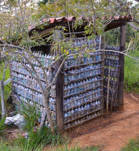 Sustainable construction in Barichara, showcasing a structure built with recycled materials surrounded by green foliage.