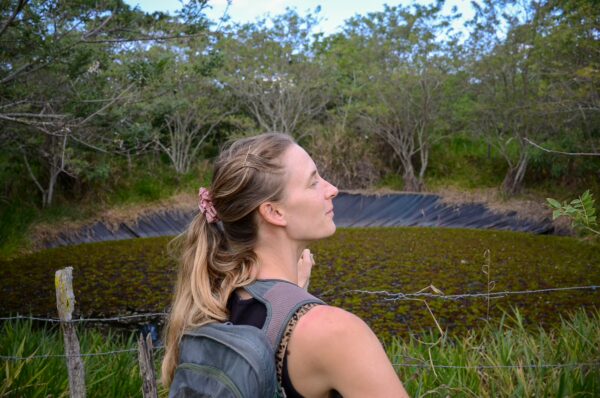 Woman with a backpack looking out over a small wetland at Móncora Biopark near Barichara, Santander