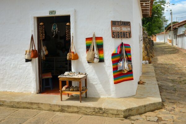 Souvenir shop in Guane, Santander, with woven bags and handmade crafts beside a cobbled Camino Real street