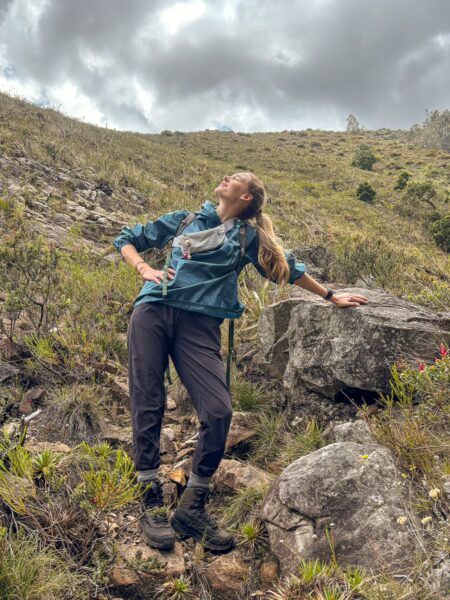 Hiker standing on a steep rocky slope above the Río Cane gorge in Iguaque National Park, Boyacá, Colombia