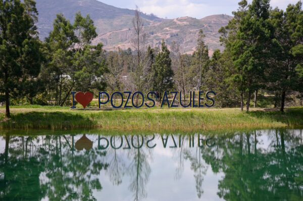Pozos Azules sign reflected in a turquoise lake at Villa de Leyva, Boyacá, Colombia
