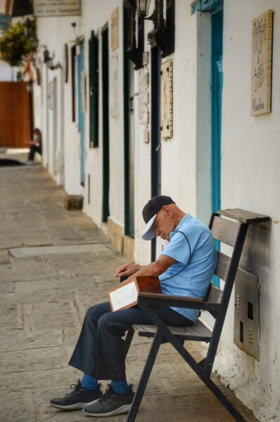 Man resting on a bench along a quiet street in Villa de Leyva, Boyacá, Colombia