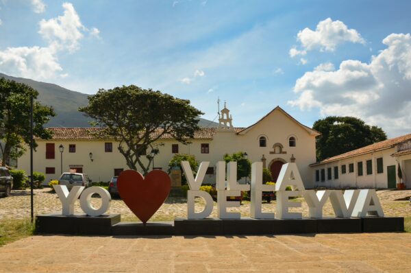 Large "Yo ❤️ Villa de Leyva" sign with Capilla San Francisco in the background, Villa de Leyva, Boyacá, Colombia