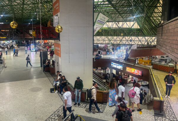 Busy interior of Terminal del Norte in Medellín, featuring vibrant architecture and travelers navigating various shops and waiting areas.