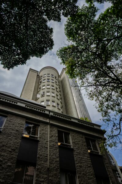 Tall buildings rise above lush green trees in Medellín, Antioquia, highlighting a blend of urban and natural elements.