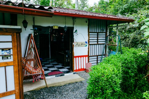 Artistic entrance with a tiled path, surrounded by greenery, in Velez, Salento, Quindio, Colombia. Colorful details enhance the charm.