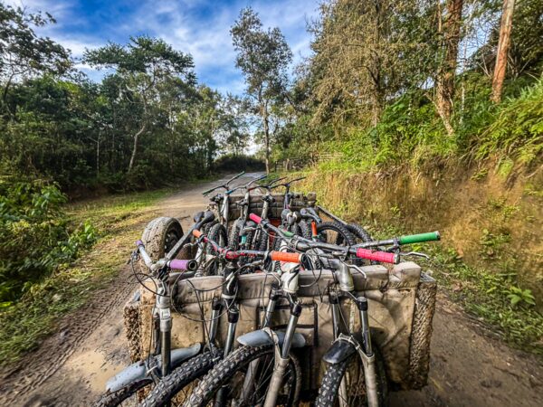 Bicycles arranged on a cart along a dirt path in Carbonera Valley, surrounded by lush greenery in Quindio, Colombia.