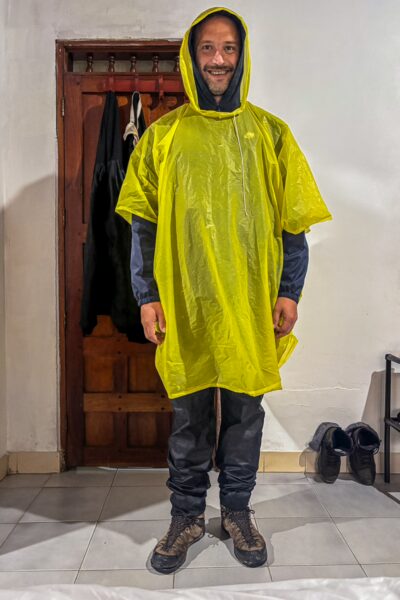 Bright yellow poncho worn by a man standing indoors, ready for an adventure in Leticia, Amazonas, Colombia.