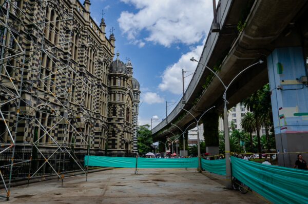 Palacio de la Cultura Rafael Uribe stands out with its intricate facade, framed by the modernity of Medellín's elevated metro line.