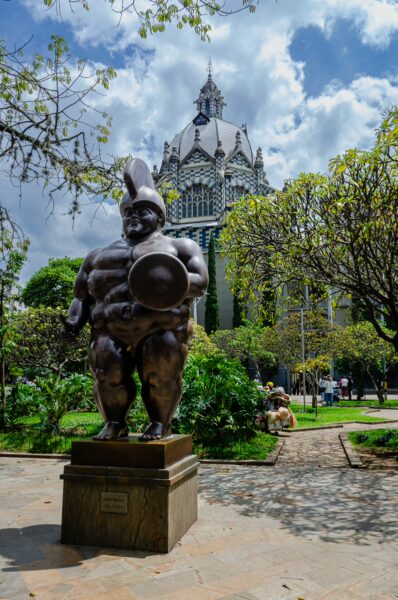 Bronze Botero sculpture in Plaza Botero with the Palace of Culture Rafael Uribe Uribe behind it in Medellín
