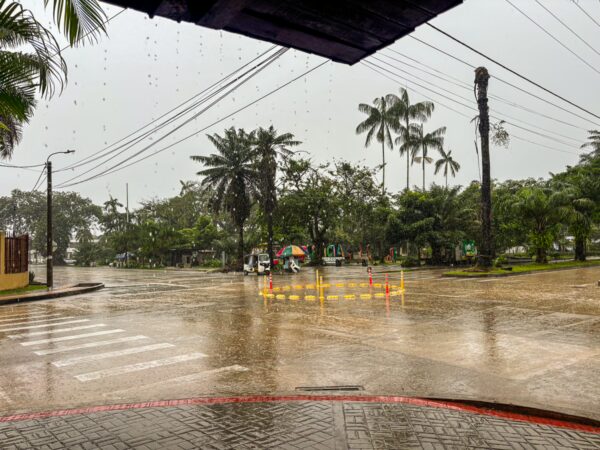Rain-soaked streets with palm trees in Leticia, Amazonas, Colombia, showcasing a vibrant yet tranquil atmosphere.