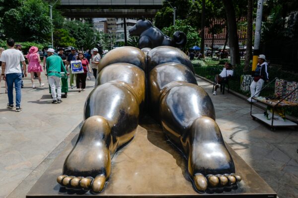 Oversized bronze Botero sculpture in Plaza Botero, Medellín, with pedestrians and street vendors around it