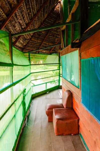 Vibrant green walls and brown seating create a cozy atmosphere in the Gamboa Nature Reserve overlooking Pirana Lake, Loreto, Peru.