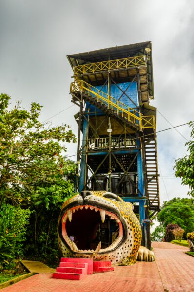 Colorful tower entrance featuring a jaguar's mouth in Puerto Narino, Amazonas, Colombia, surrounded by lush greenery.