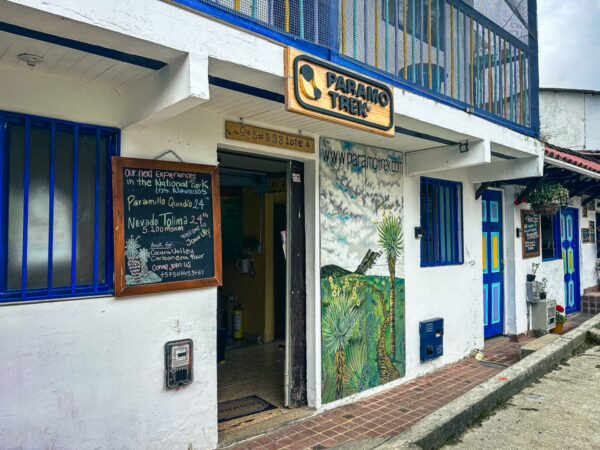 Vibrant café exterior in Salento, Quindío, Colombia, featuring colorful blue accents and a charming mural of pineapples.