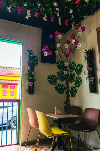 Brightly decorated with colorful flowers and plants, Skywind Café features a cozy seating area in Salento, Quindio, Colombia.
